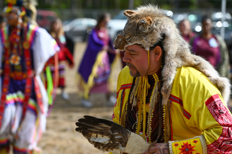 Participant in full traditional regalia leads the group in dance.