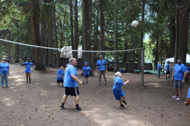 Campers and counselors play volleyball.