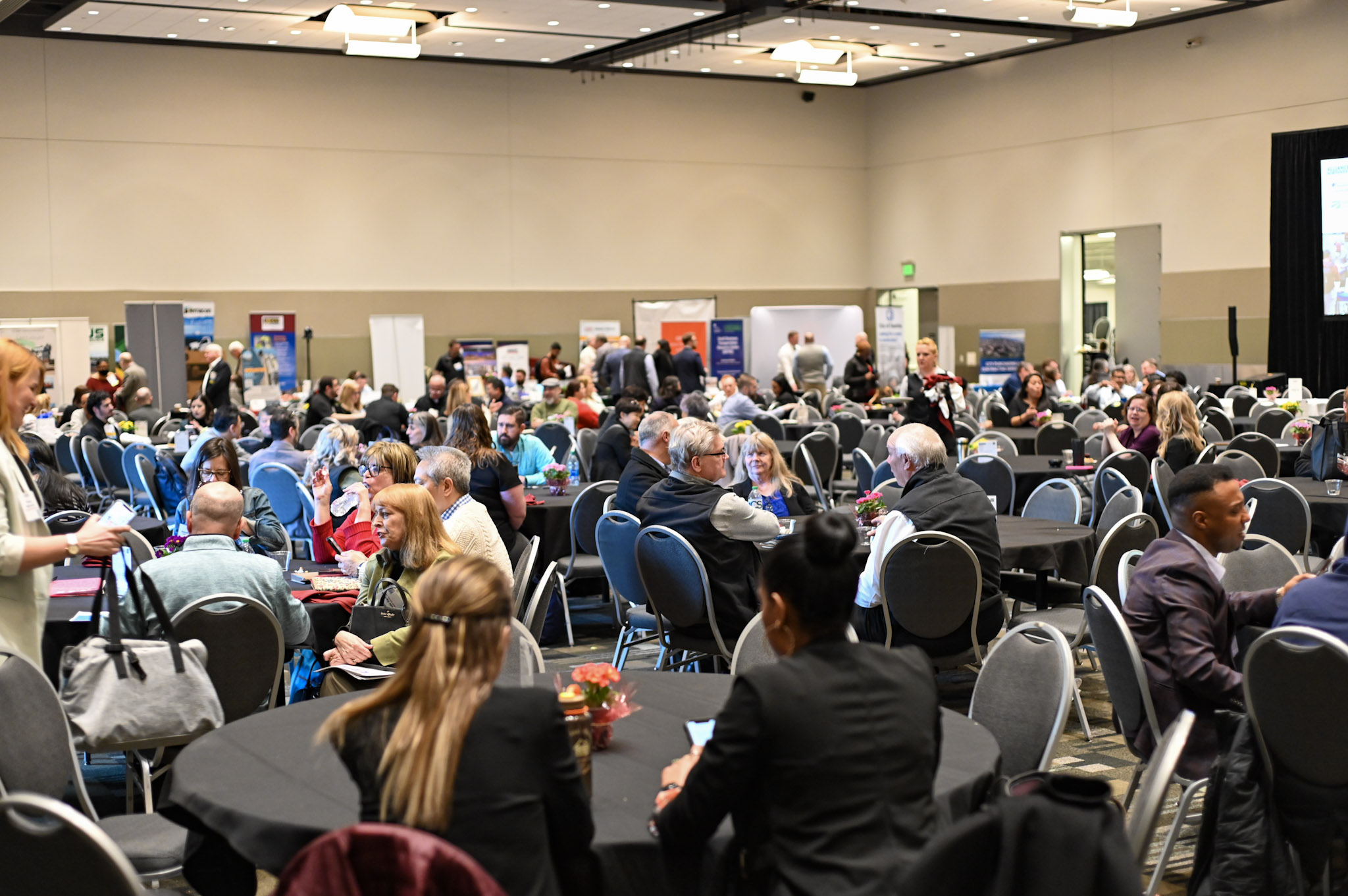 group of people sitting at tables at vendor event