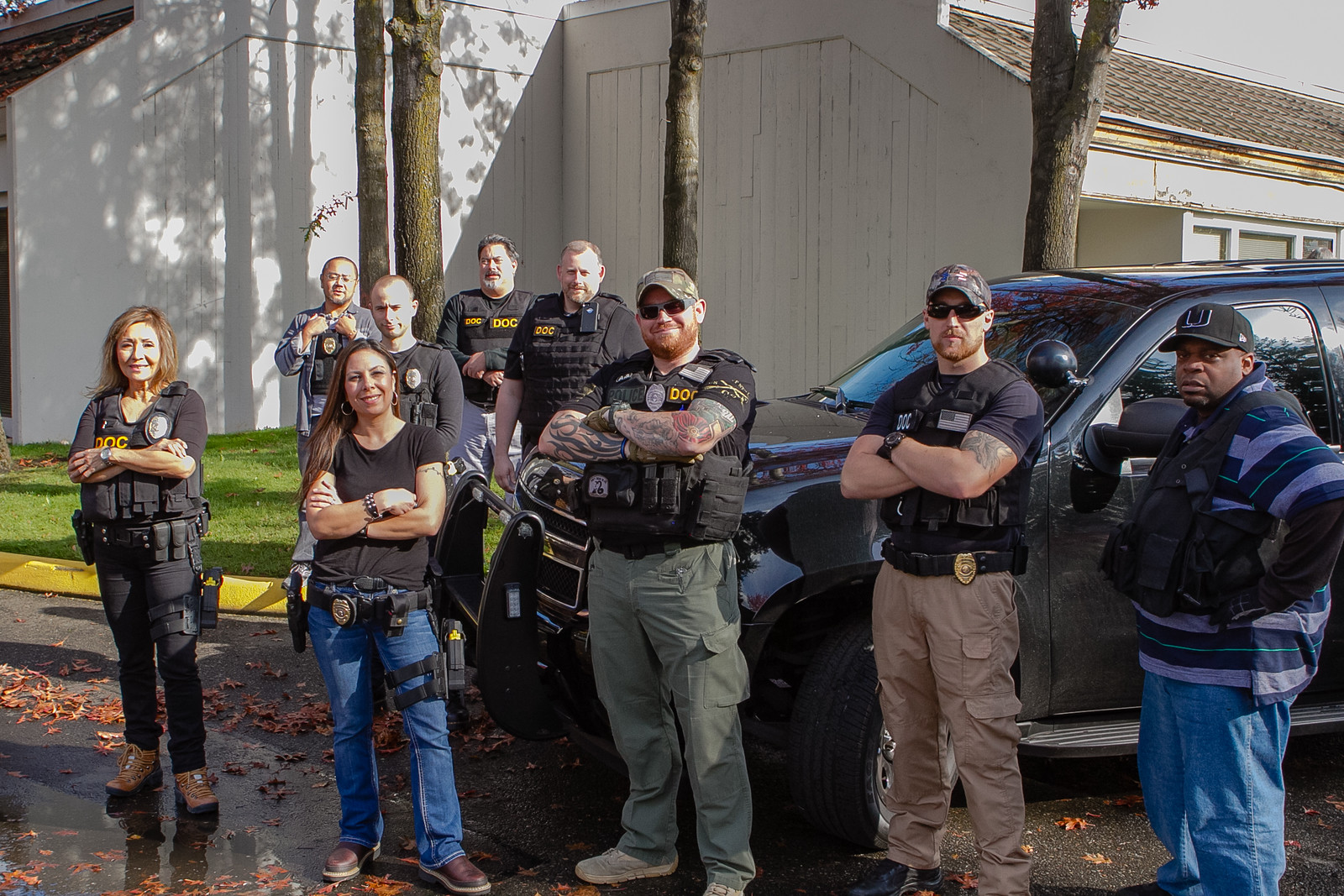 Five Community Corrections Officers pose for a photo with a Department van