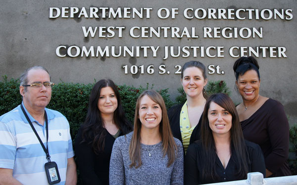image of the outside of the Tacoma Community Justice Center with six staff members posing