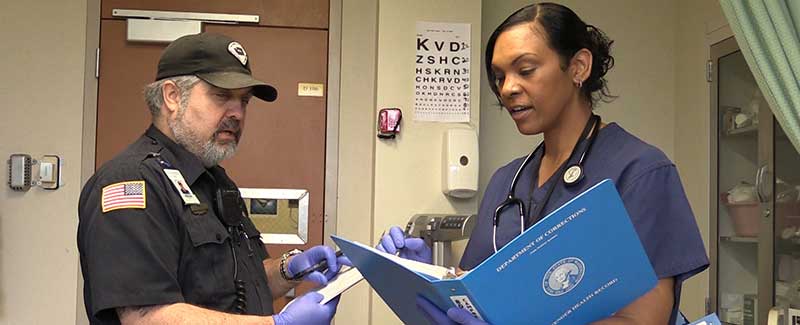 Correctional Officer and Nurse working together sharing notes