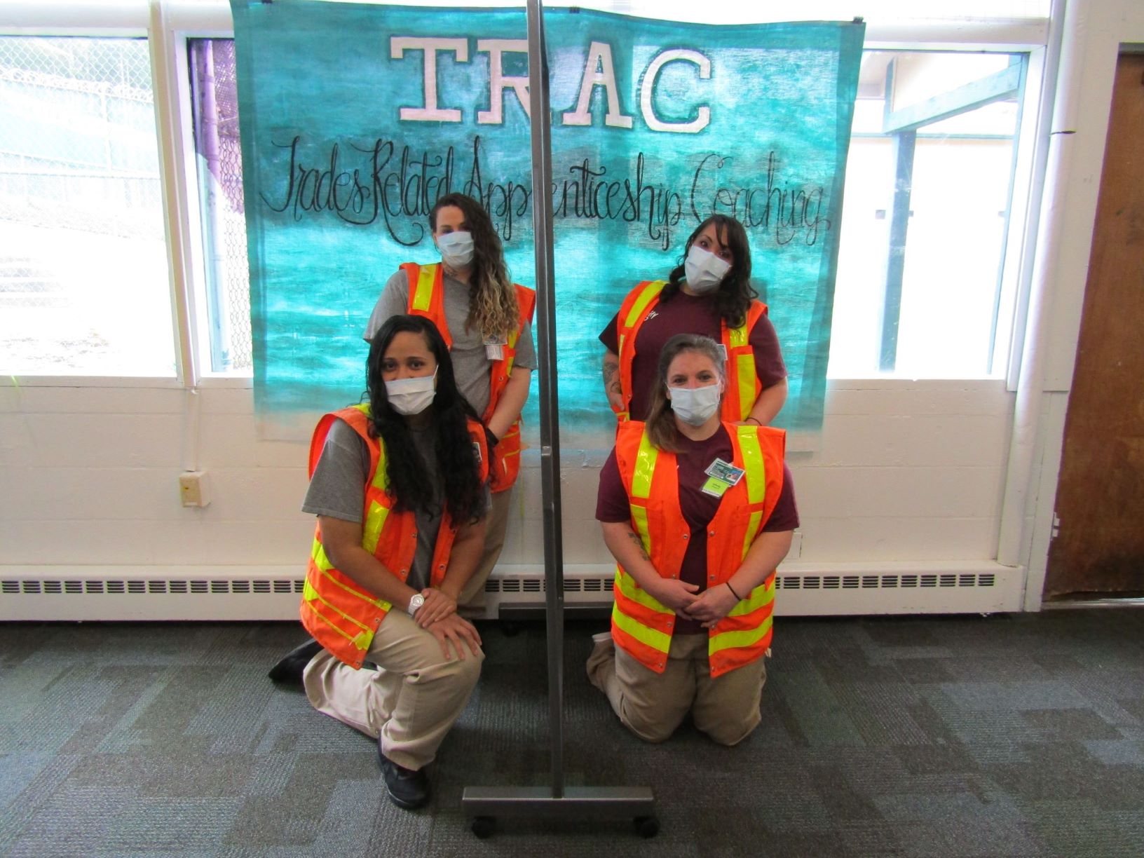 TRAC Graduates pose in front of TRAC Banner