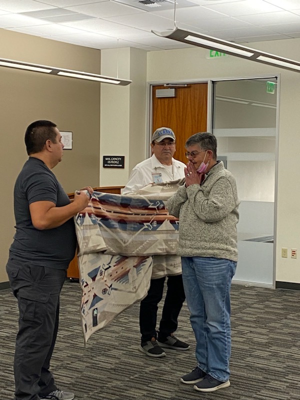 Woman receives tribal blanket from man