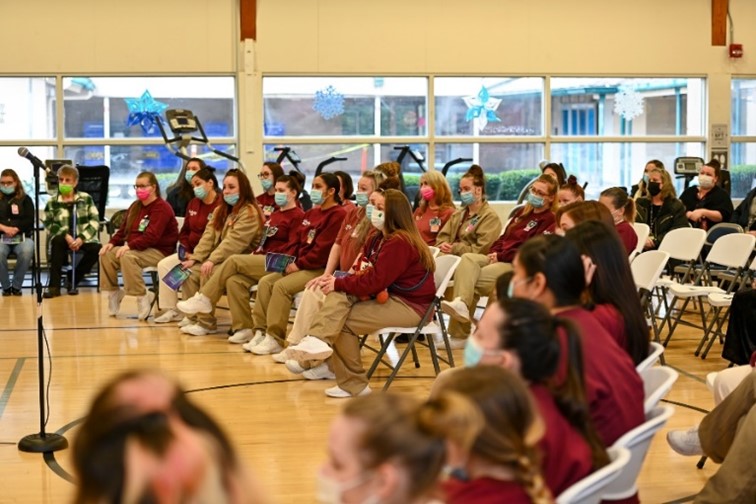 Incarcerated individuals listen to recent graduates of the Therapeutic Community program.