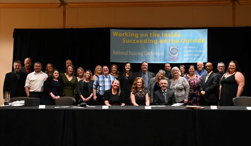 Large group of people posing for a photo on stage.