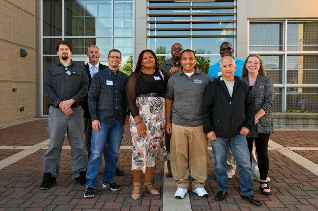 A group of people stand together in front of a building.