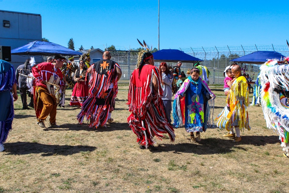 Participants dance together at powwow