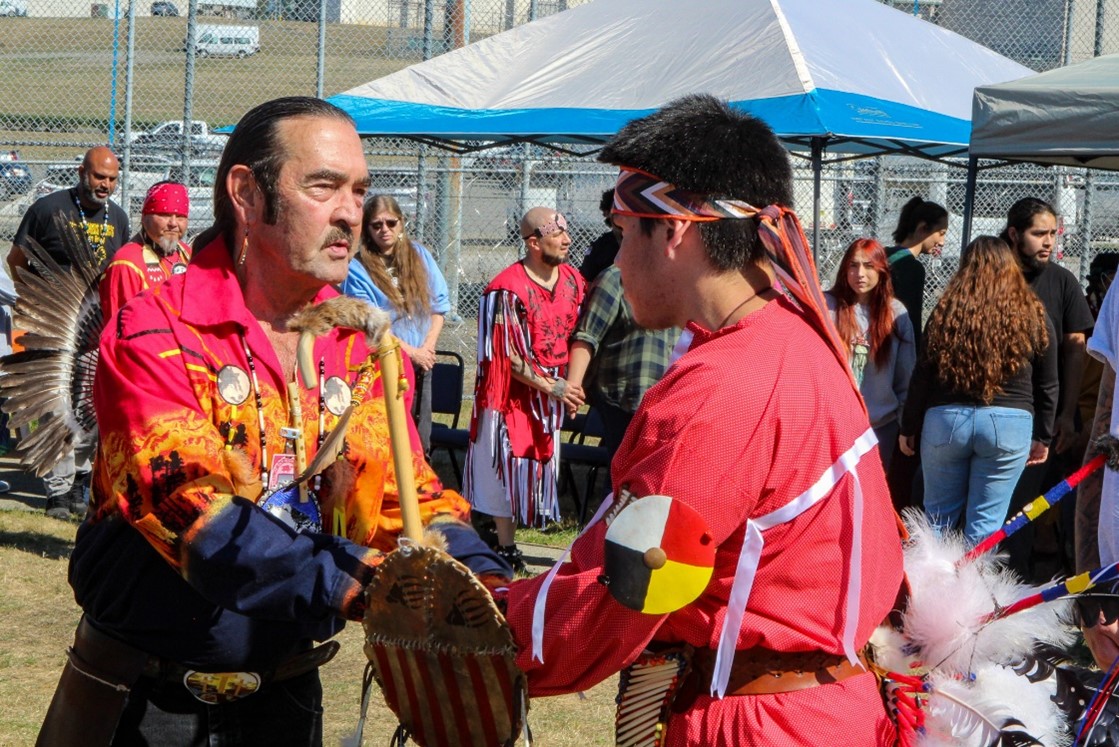 Member greets participants at powwow