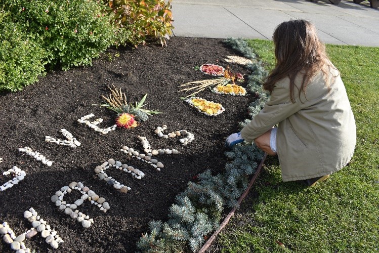 An incarcerated individual working in the garden creating art out of rocks.