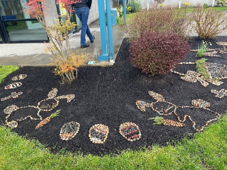 A garden featuring rocks depicting rabbits, carrots, eggs, and other spring-themed designs.