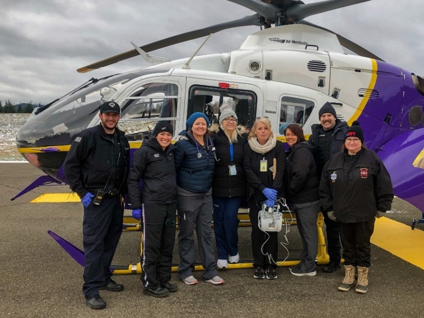 CBCC staff standing in front of a helicopter