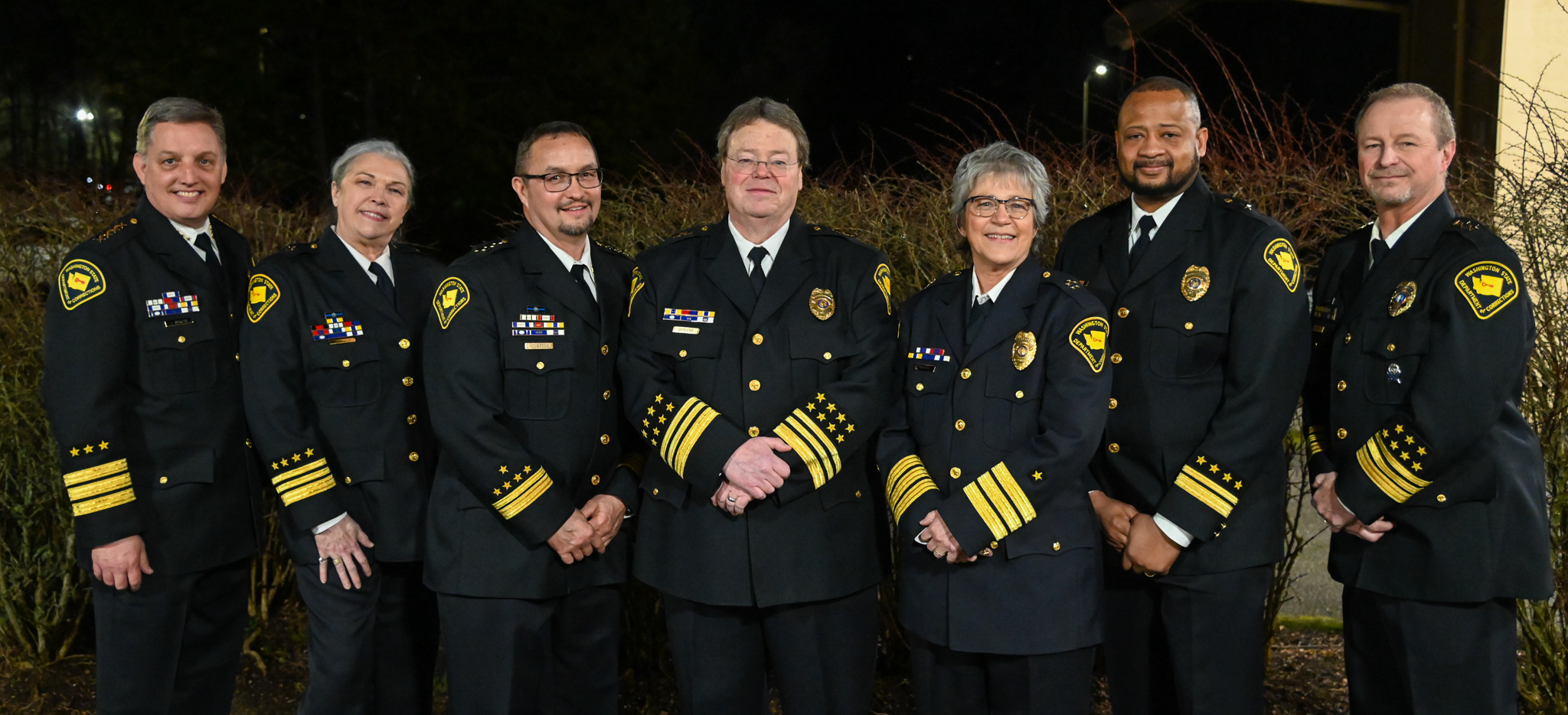 A group posing for a photo in their dress blues.