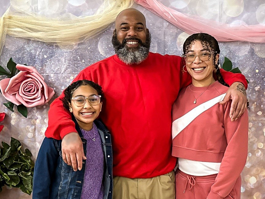 Incarcerated individual, Rodney Herbert takes a photo with his daughters Talyah and Mahealani.