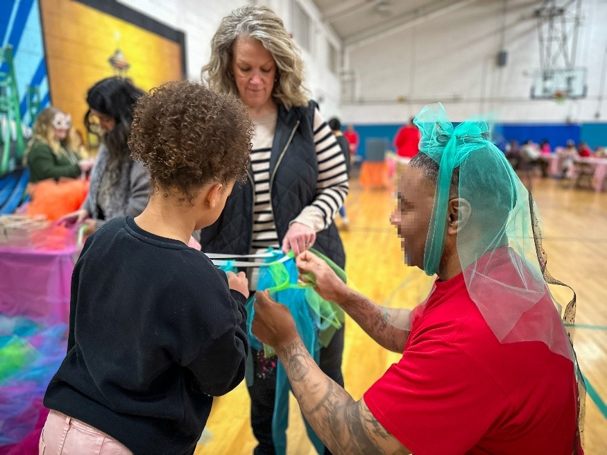 Incarcerated individual, John and his wife Jodi, build a tutu with their granddaughter Ivy.