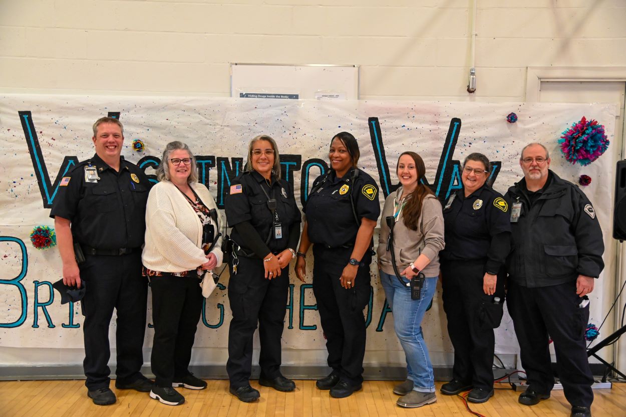 A group standing in front of a banner.