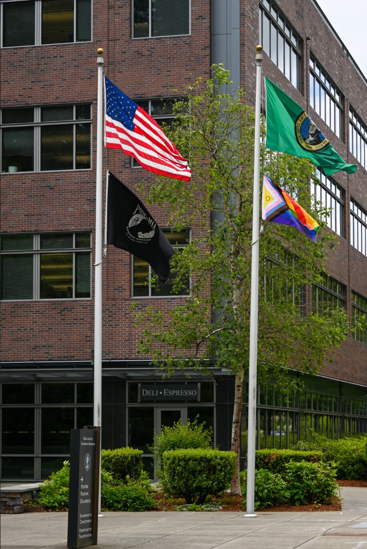 Four flags raised in front of a building