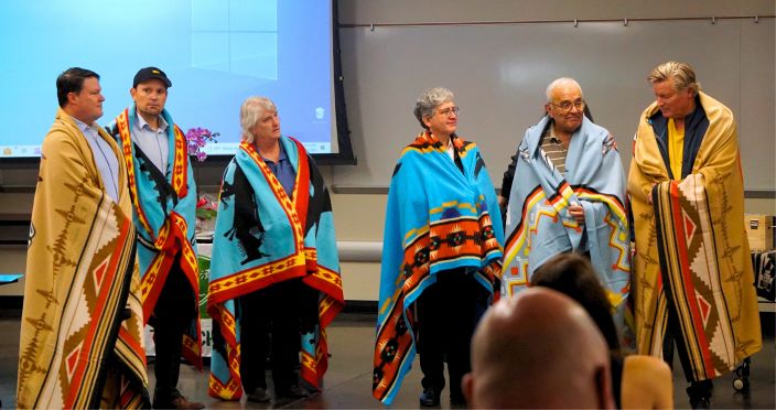 photo of people with tribal blankets over backs