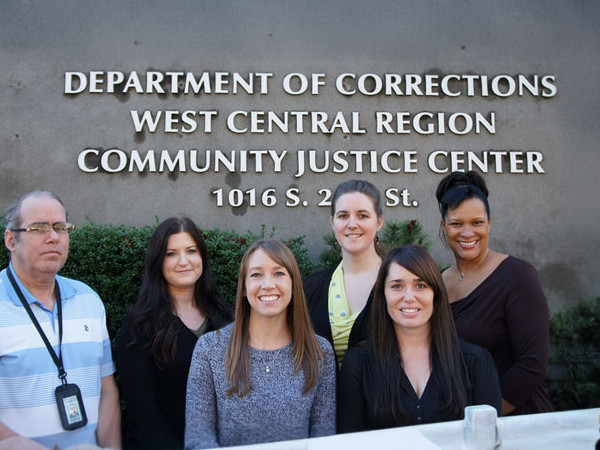image of the outside of the Tacoma Community Justice Center with six staff members posing